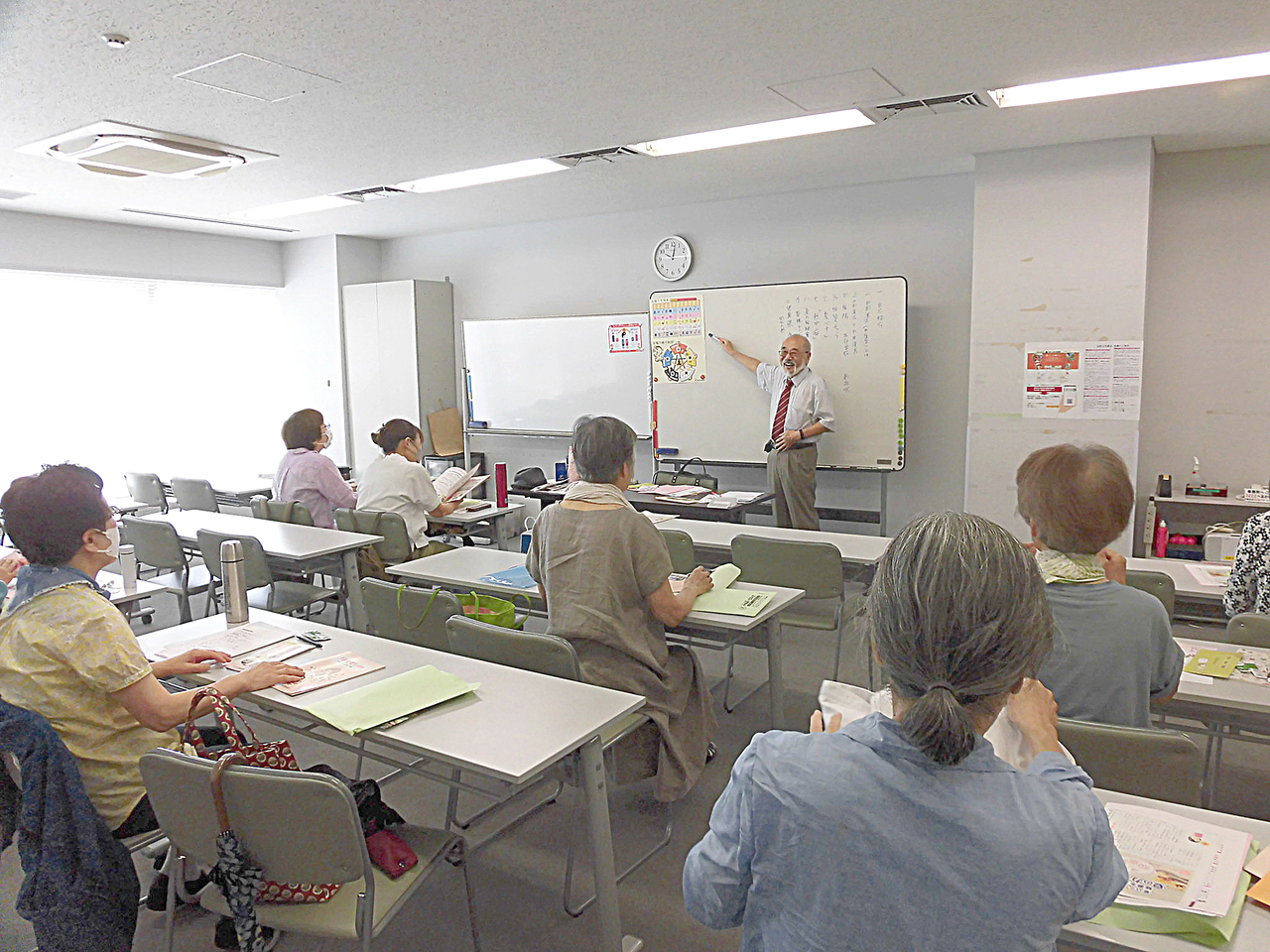 講演会の様子。たくさんの人が集まった教室で講演している種田生司の写真